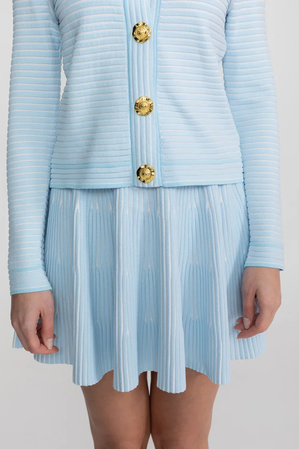 Conjunto em Tricô Estruturado -  Cardigan com Botões Dourados e Saia Plissada