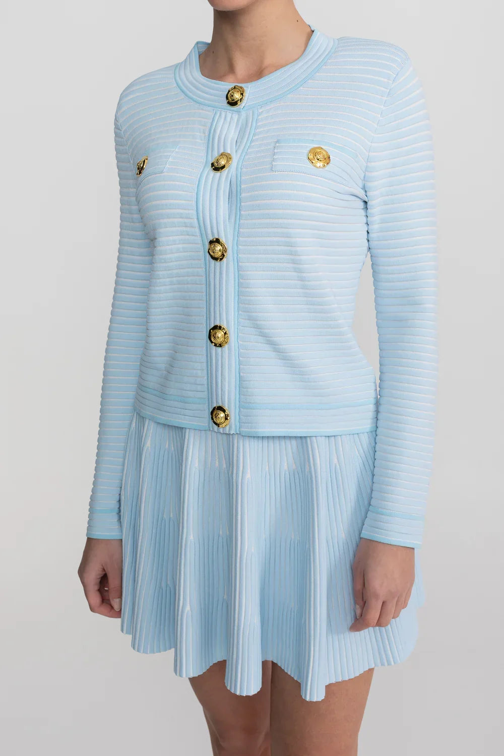 Conjunto em Tricô Estruturado -  Cardigan com Botões Dourados e Saia Plissada